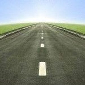 2296941-shot-of-a-tarmac-road-leading-into-the-horizon-and-the-sun-with-a-blue-gradient-sky.jpg